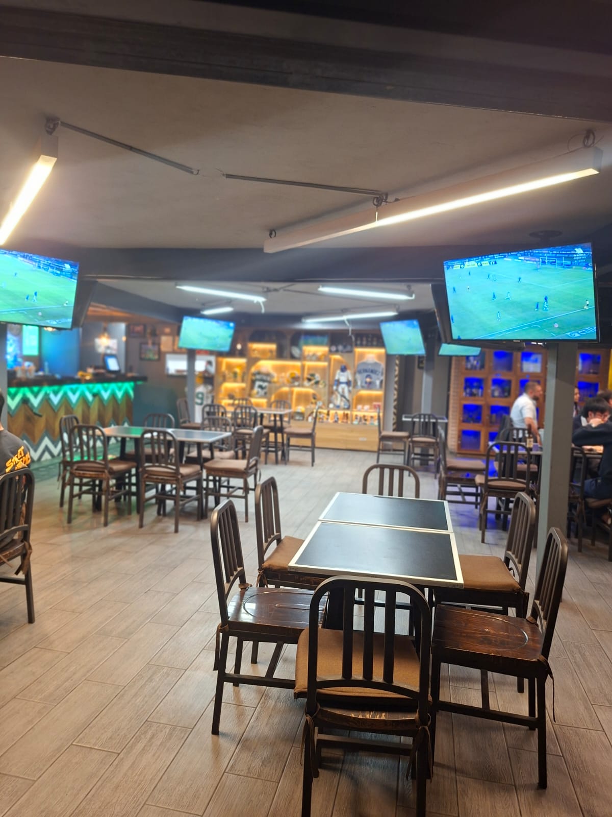 Interior del lugar con mesas y pantallas