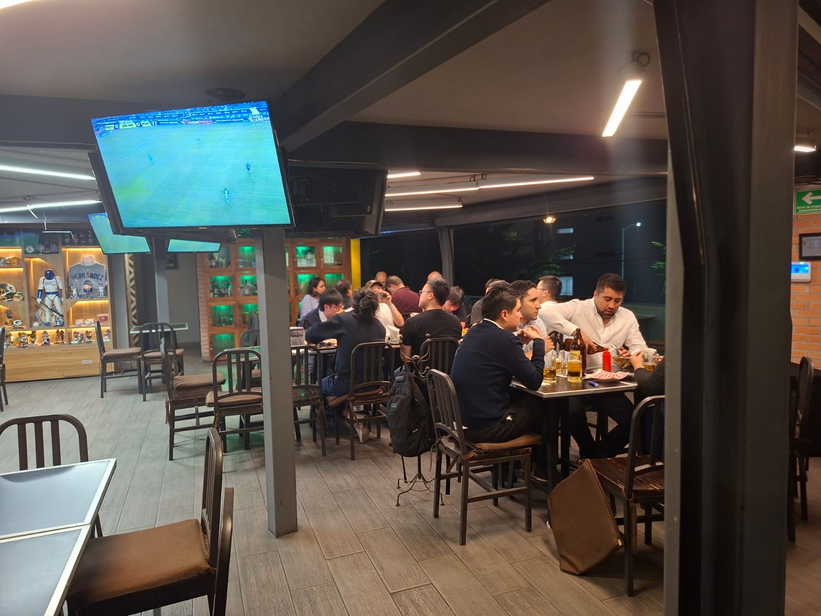 Interior con múltiples pantallas transmitiendo deportes