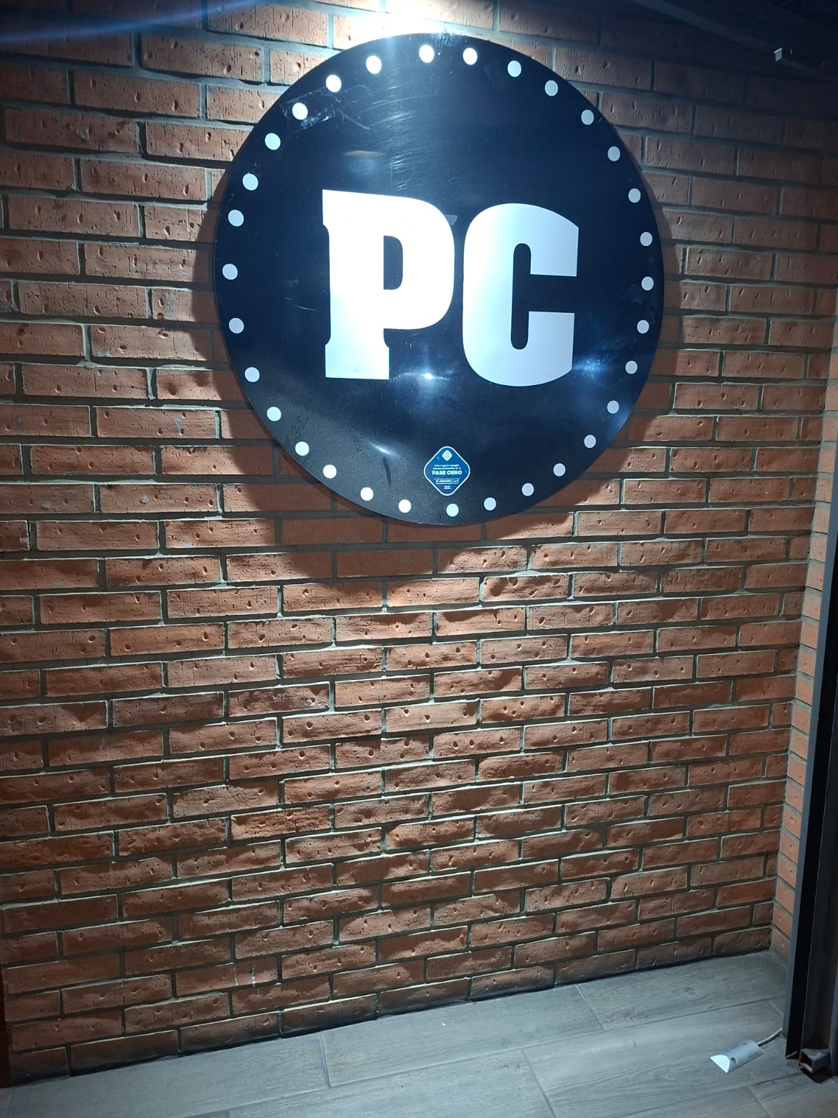 Logo PC en pared de ladrillo